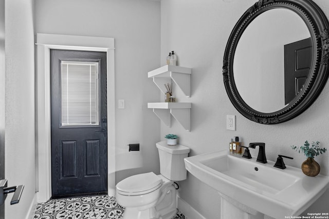 bathroom featuring sink, toilet, and tile patterned flooring