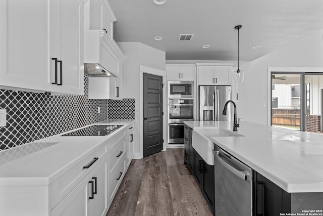 kitchen featuring white cabinetry, sink, hanging light fixtures, and appliances with stainless steel finishes