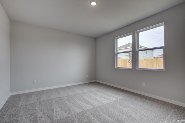 empty room with carpet floors, recessed lighting, and baseboards