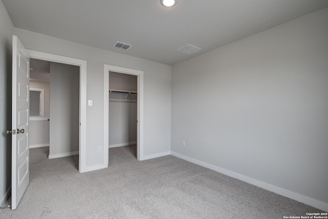 unfurnished bedroom with a closet, carpet flooring, visible vents, and baseboards