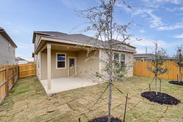 rear view of property with a lawn, a patio area, and a fenced backyard