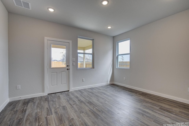 unfurnished room with dark wood-style flooring, recessed lighting, visible vents, and baseboards