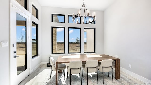 dining area featuring light hardwood / wood-style flooring, a chandelier, and a healthy amount of sunlight