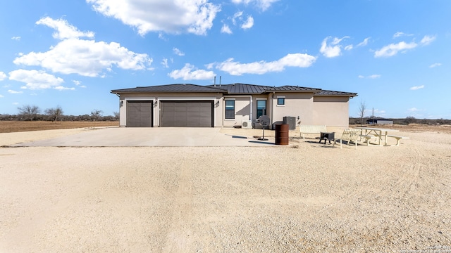 view of front of property with central AC and a garage