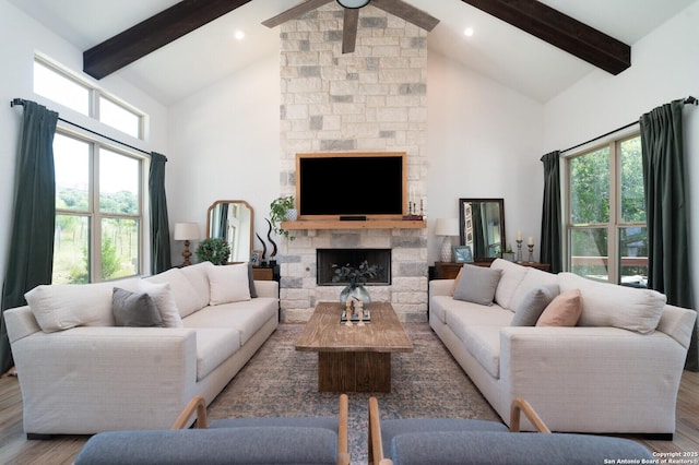 living room with hardwood / wood-style flooring, high vaulted ceiling, beam ceiling, and a fireplace