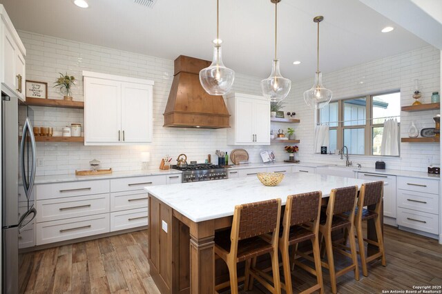 kitchen with premium range hood, a center island, and white cabinets