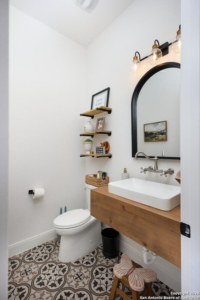 bathroom featuring sink, toilet, and tile patterned flooring