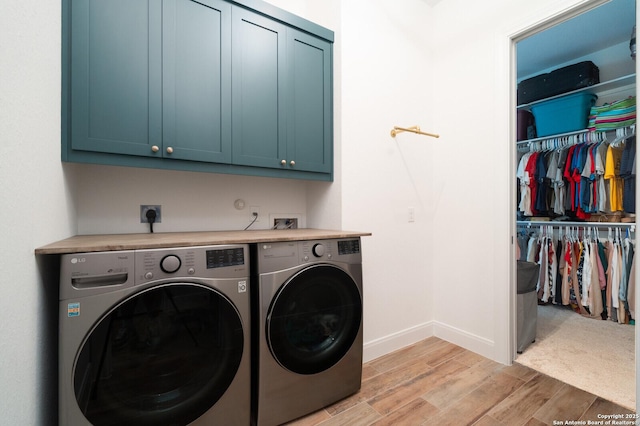 washroom featuring cabinets and washing machine and dryer