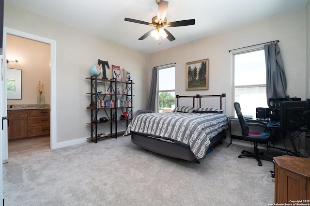 bedroom with ceiling fan, connected bathroom, and light carpet