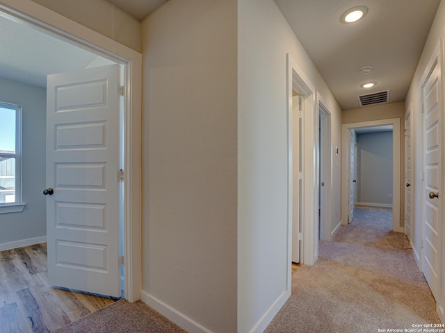 corridor featuring light colored carpet