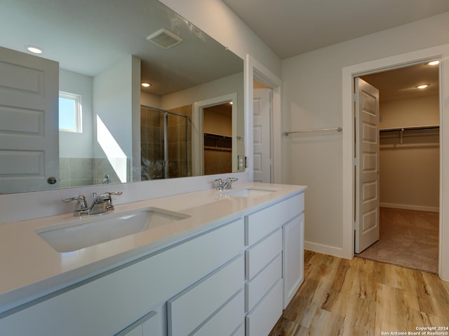 bathroom with vanity, walk in shower, and hardwood / wood-style floors