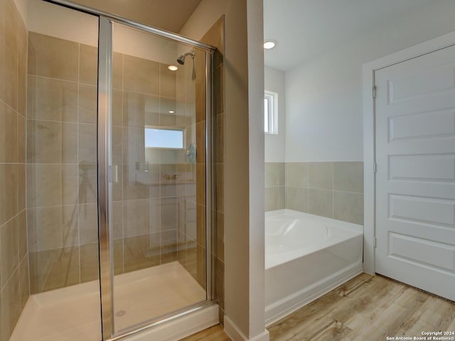 bathroom featuring hardwood / wood-style floors and independent shower and bath