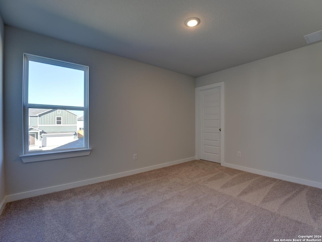 unfurnished room featuring light carpet