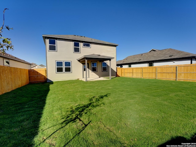 rear view of house with a yard and a patio