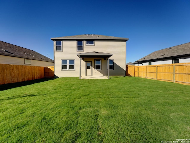 back of house with a patio area and a yard