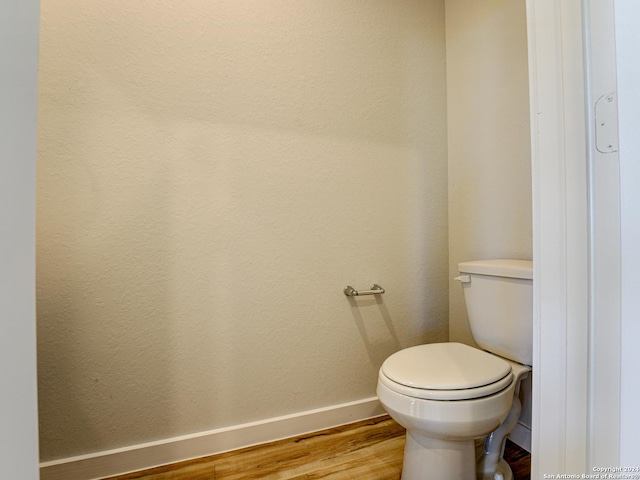 bathroom featuring wood-type flooring and toilet