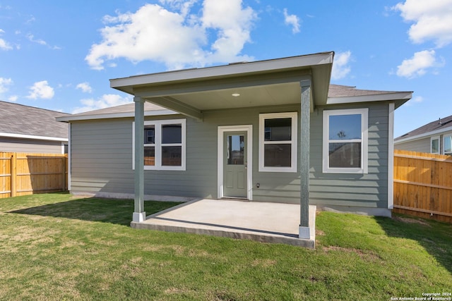 rear view of property featuring a yard and a patio