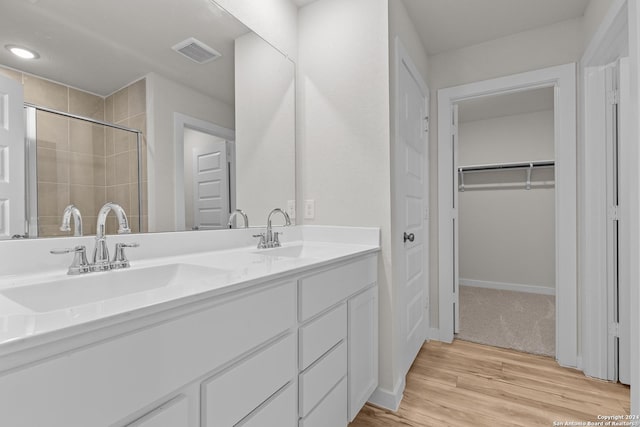 bathroom with vanity, hardwood / wood-style flooring, and walk in shower
