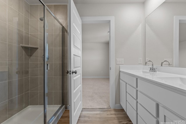 bathroom featuring hardwood / wood-style flooring, vanity, and an enclosed shower