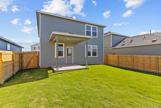 back of property with a patio and a lawn