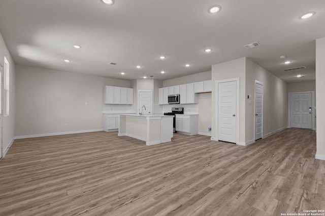 unfurnished living room with sink and light hardwood / wood-style flooring