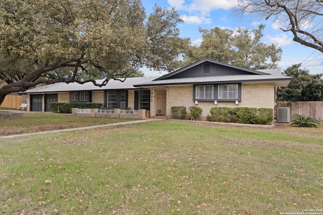 single story home with a garage, a front lawn, and central air condition unit