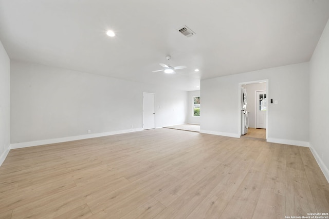 spare room with light hardwood / wood-style floors, washer / dryer, and ceiling fan