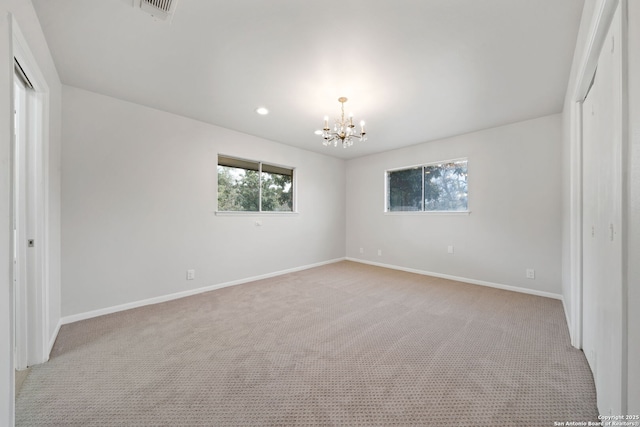 unfurnished bedroom with light carpet and a chandelier