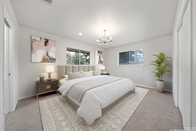 bedroom with a notable chandelier, light carpet, and a closet