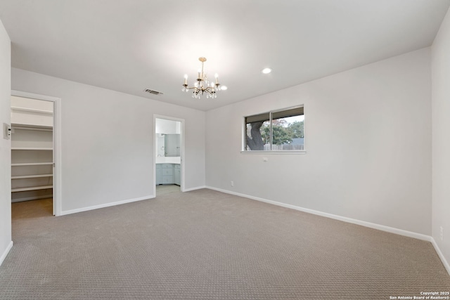 carpeted spare room with a notable chandelier