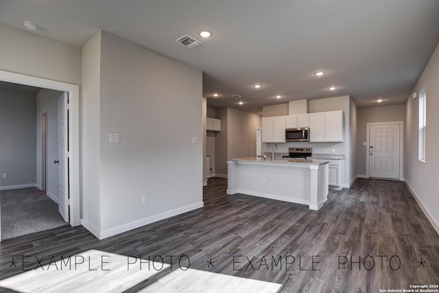 kitchen featuring stainless steel appliances, white cabinetry, light stone counters, and dark wood-type flooring