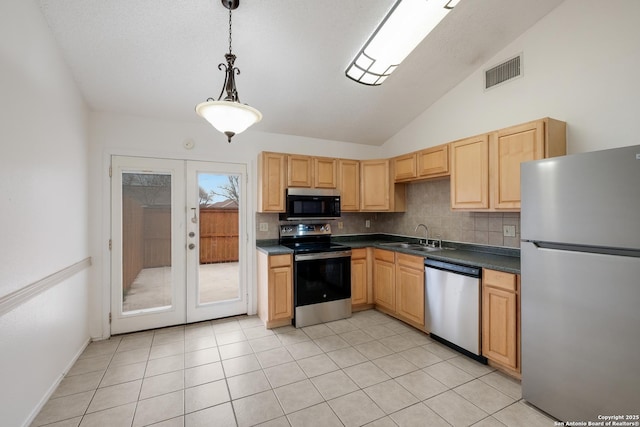 kitchen with stainless steel appliances, sink, hanging light fixtures, vaulted ceiling, and light tile patterned floors