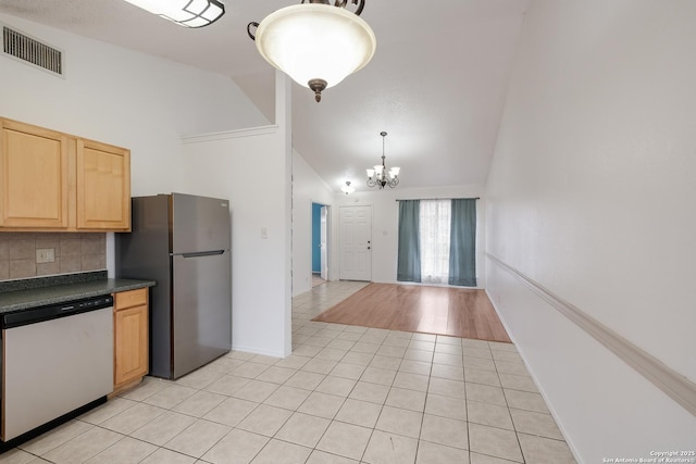 kitchen featuring decorative light fixtures, stainless steel appliances, tasteful backsplash, a notable chandelier, and light tile patterned floors