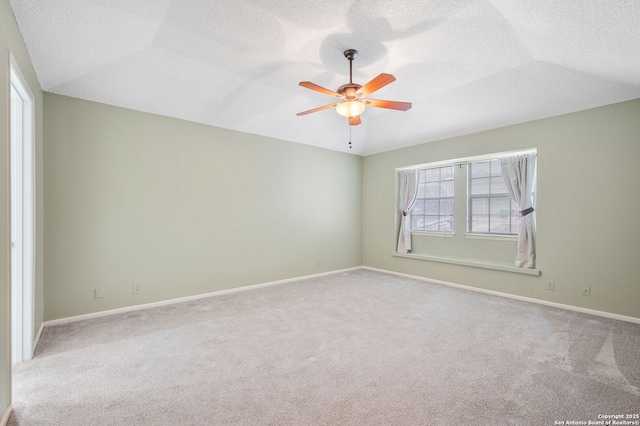 unfurnished room with vaulted ceiling, light colored carpet, a textured ceiling, and ceiling fan