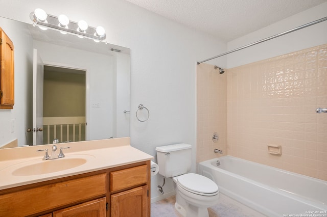 full bathroom featuring tiled shower / bath, vanity, a textured ceiling, and toilet