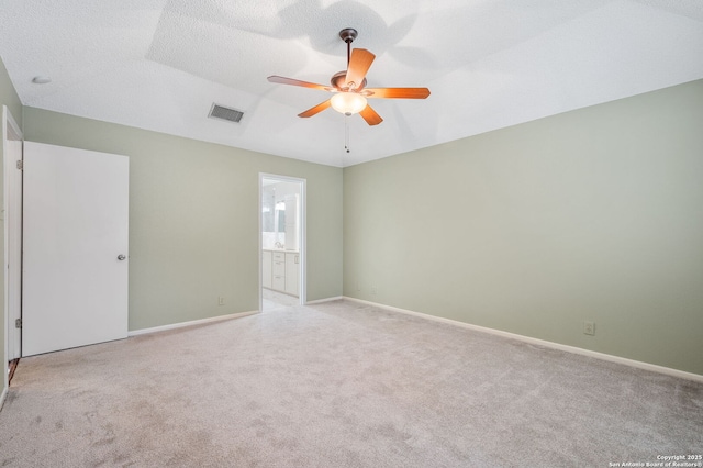 carpeted spare room with a textured ceiling and ceiling fan