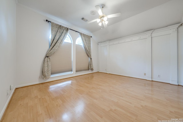 empty room with vaulted ceiling, ceiling fan, and light hardwood / wood-style flooring