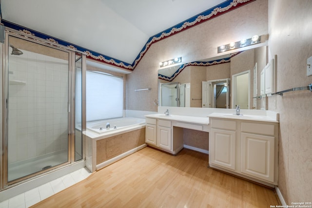 bathroom with hardwood / wood-style floors, vanity, vaulted ceiling, and shower with separate bathtub