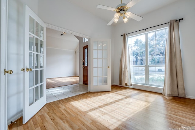 spare room featuring light hardwood / wood-style floors, a healthy amount of sunlight, and french doors