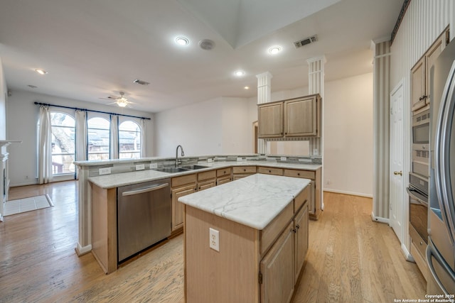 kitchen with sink, a center island, light hardwood / wood-style flooring, and stainless steel appliances