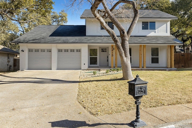 view of front property with a garage, covered porch, and a front lawn