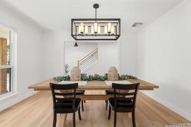 dining room with hardwood / wood-style flooring and ornamental molding