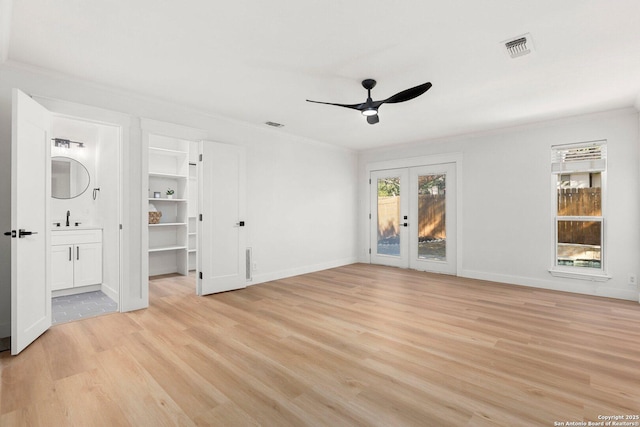 unfurnished living room featuring french doors, sink, ceiling fan, crown molding, and light hardwood / wood-style flooring