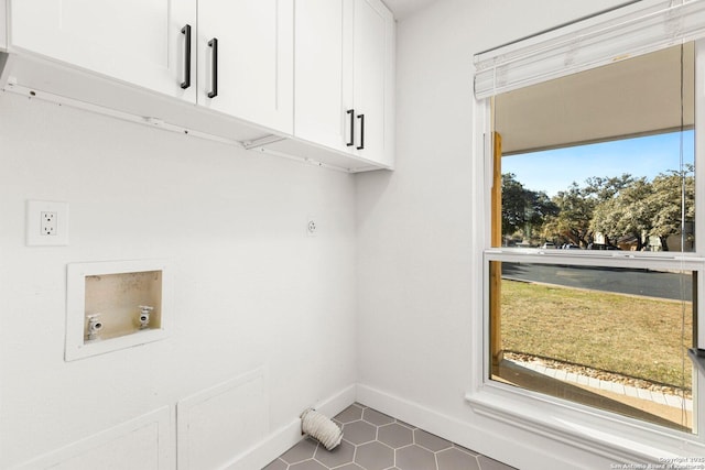 washroom featuring cabinets, washer hookup, hookup for an electric dryer, and dark tile patterned floors