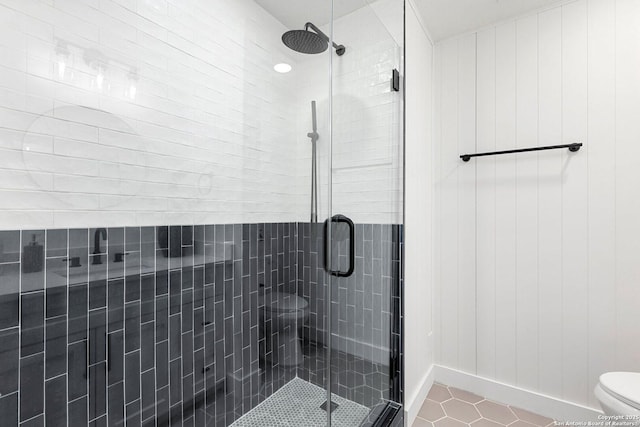 bathroom with tile patterned flooring, a shower with shower door, and toilet