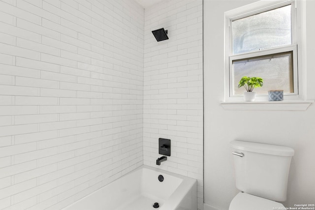 bathroom with tiled shower / bath combo and toilet