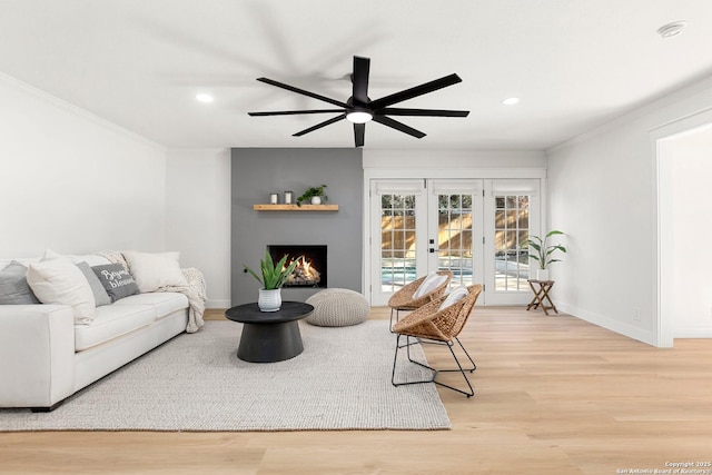 living room featuring crown molding, light hardwood / wood-style flooring, french doors, and ceiling fan