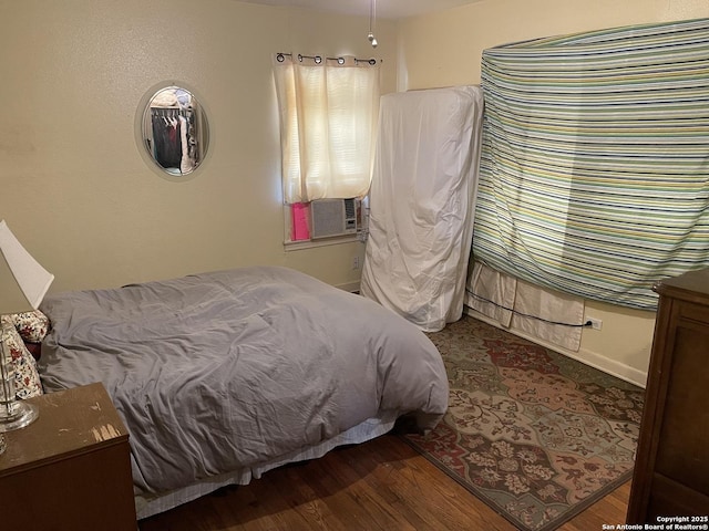 bedroom with cooling unit and dark hardwood / wood-style floors