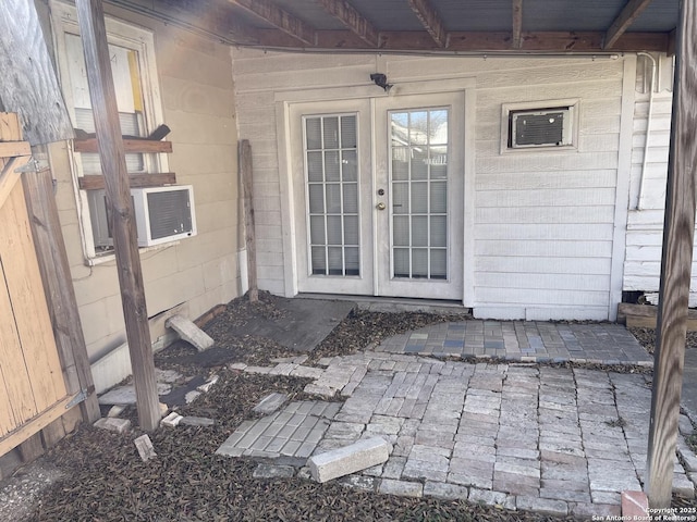 entrance to property with a patio area, cooling unit, and french doors