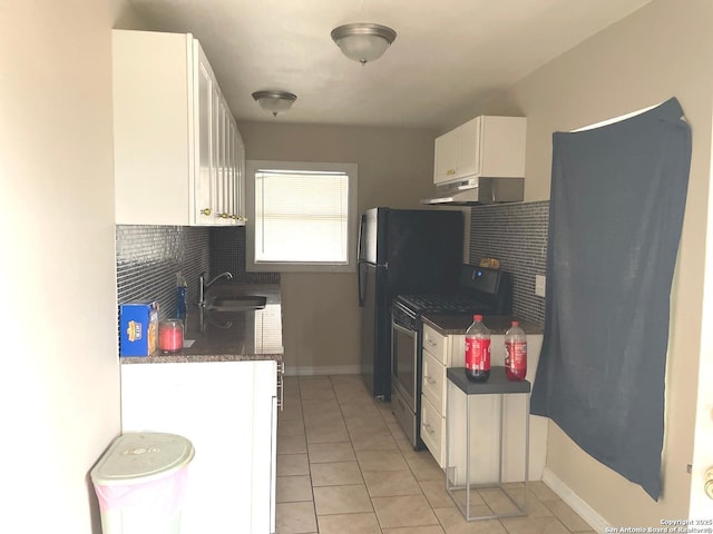 kitchen with sink, black refrigerator, stainless steel gas range oven, white cabinets, and light tile patterned flooring